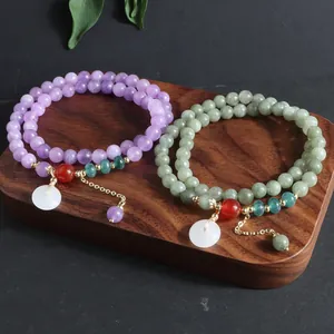Vista detallada de pulseras de piedra natural con colgantes de botón de seguridad