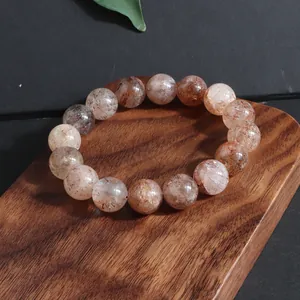 Detalle de pulsera de cuentas de cristal natural Super Seven en soporte de madera