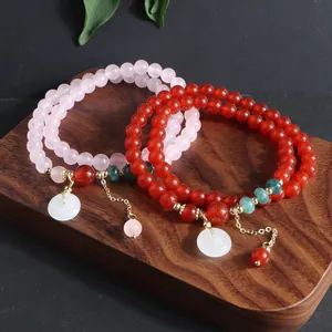 Vista detallada de pulseras de piedras naturales con colgantes de jade blanco.