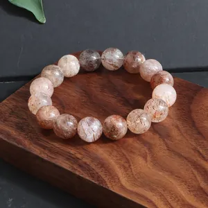 Primer plano de una pulsera de cristal natural Super Seven sobre una base de madera.