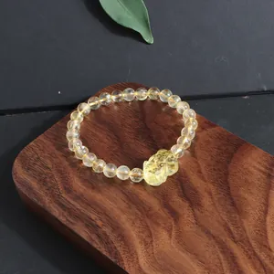 Macro view of translucent natural yellow citrine beaded bracelet with detailed fox carved pendant