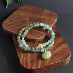 Detailaufnahme eines doppelreihigen Armbands aus grünem Jadeit mit Ping An Kou Anhänger