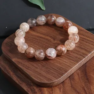 Primer plano de pulsera de cuarzo Super Seven natural sobre base de madera