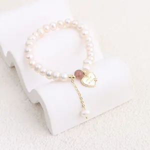 Detail of freshwater pearl bracelet with gold heart charm and sunstone bead