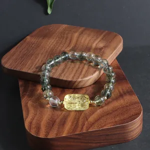 Exquisite close-up of a Green Phantom crystal bracelet featuring a carved yellow lion charm