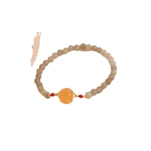 Moonstone and chalcedony bracelet featuring an orange pumpkin bead on a white background