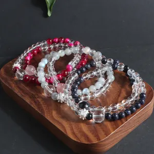 Detailed high-quality view of various natural stone crystal beaded bracelets on a wooden base