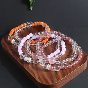 Detailed close-up of stacked natural stone beaded bracelets with pink and orange crystals