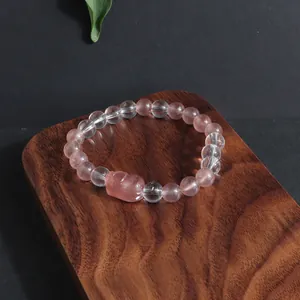 Gros plan d'un bracelet en perles de quartz fraise et cristal clair Pixiu