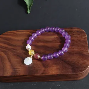 Nahaufnahme Amethyst-Perlenarmband mit einem weißen Jade-Friedensschloss und Perle