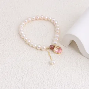 Detailed view of natural freshwater pearl bracelet with pink heart crystal pendant.