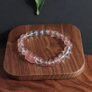 Gros plan détaillé du bracelet en quartz fraise et cristal blanc avec breloque Pixiu