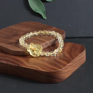 Detailed macro view of natural citrine beaded bracelet featuring a hand-carved fox charm