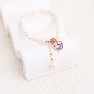 Detailed macro shot of freshwater pearl bracelet featuring purple heart zircon pendant.