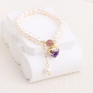 Detailed close-up of natural freshwater pearl bracelet with purple heart zircon pendant