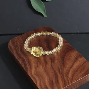 Close-up detail of natural yellow citrine crystal bracelet with carved fox charm.
