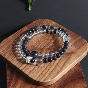 Macro detail of natural blue sandstone and clear crystal beaded bracelets on wood