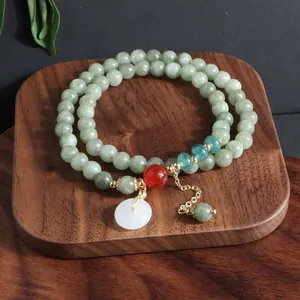 Vista detallada de una pulsera de piedra natural de varias vueltas con dije blanco