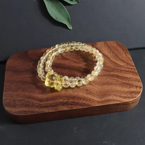 Natural citrine double-strand bracelet featuring a carved fox charm on wooden display block