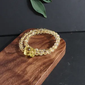 Elegant natural citrine bead bracelet with fox charm detail on a dark wood board