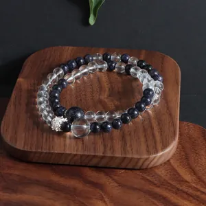 Macro detail of natural white crystal and blue goldstone beaded bracelet on wood.