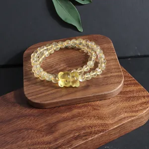 Detailed macro view of natural yellow citrine crystal bracelet with a carved fox pendant