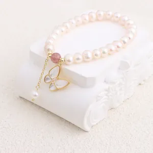 Detail of freshwater pearl bracelet with butterfly shell pendant and gold accents