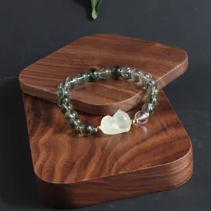 Exquisite close-up of green ghost crystal bracelet featuring a yellow lion pendant design