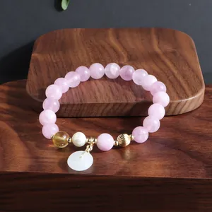 Detailansicht des rosa Amethyst-Armbands mit weißem Jade-Friedensknopf und Perle.