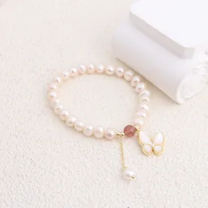 Close-up of elegant freshwater pearl bracelet with butterfly shell pendant on white background