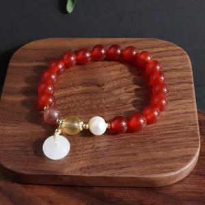 Detailansicht eines Armbands aus rotem Achat mit weißer Jadeschnalle und Perle