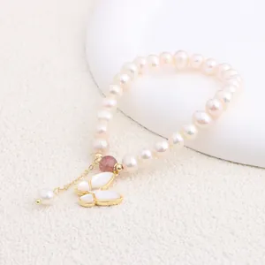 Close-up view of elegant freshwater pearl bracelet featuring a butterfly shell charm