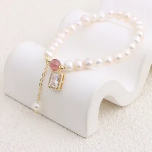 Macro close-up of a natural freshwater pearl bracelet with a gold zircon pendant