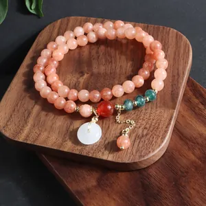 Detalle de pulsera de piedra natural de varias vueltas con colgante de jade blanco