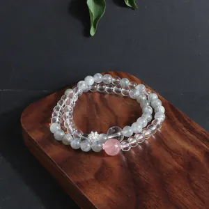 Close-up of mixed natural stone crystal bracelets displayed on a walnut block