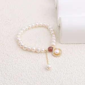 Detail showing a natural freshwater pearl bracelet featuring a shell pendant and stone