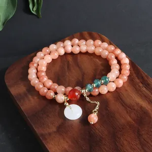 Primer plano de pulsera de piedra natural de varias vueltas con colgante de jade blanco