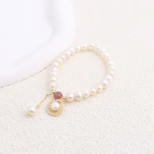 Close-up of elegant freshwater pearl bracelet with shell charm and zircon accents
