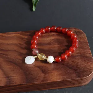 Detailaufnahme des roten Achat-Armbands mit weißem Jade-Donut und Perle
