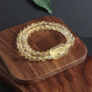 Close-up detail of natural citrine double-strand bracelet with carved fox charm