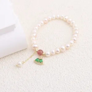 Close-up of a natural freshwater pearl bracelet with a green fan-shaped pendant