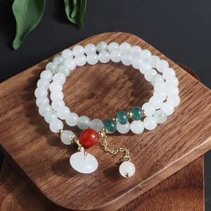 Primer plano de pulsera de doble vuelta de piedras naturales con colgante Ping'an Kou de jade