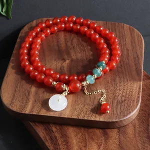 Vista detallada de cuentas de ágata roja natural con jadeíta azul y colgante de jade