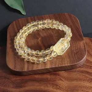 Detail view of natural yellow citrine bracelet with carved nine-tailed fox charm