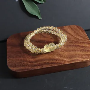 Close-up of a natural citrine beaded bracelet featuring a hand-carved Pixiu charm