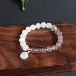 Detailansicht eines chinesischen Perlenarmbands mit weißem Jade-Friedensanhänger.