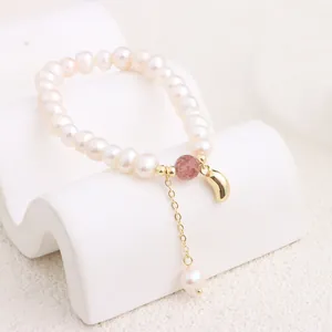 Detailed view of natural freshwater pearl bracelet with pink strawberry quartz bead.