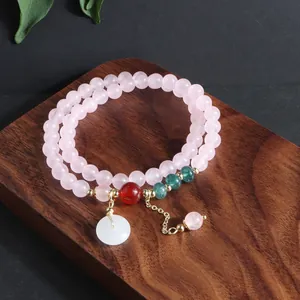 Vista detallada de pulsera multicapa de cuarzo rosa con colgante de hebilla ping'an de jade blanco