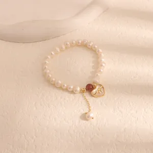 Detailed view of freshwater pearl bracelet with elegant heart-shaped shell pendant.