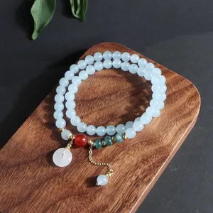 Vista detallada de pulsera multicapa de piedra natural azul con colgante de jade